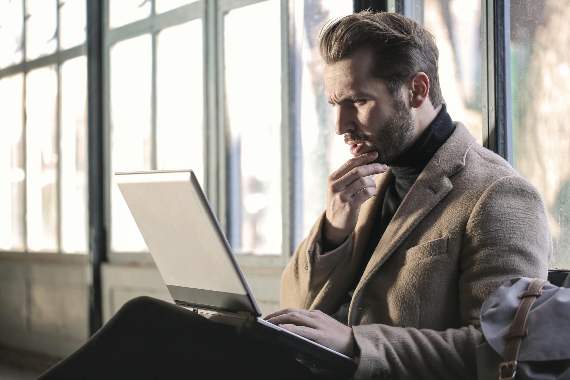 A B2B salesperson pausing at a laptop screen, quietly reconsidering a vendor selection decision