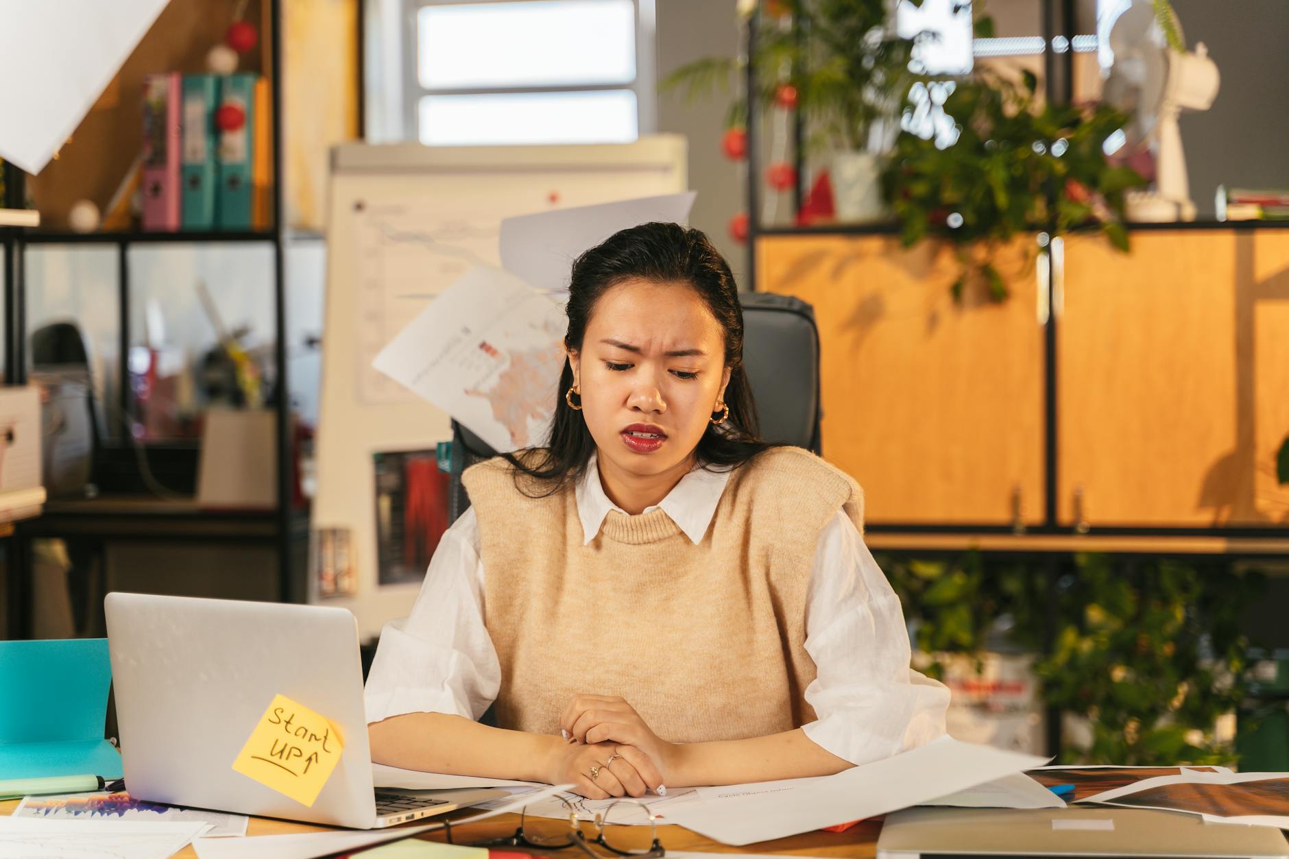 수출 담당자가 텅 빈 이메일 받은편지함을 바라보며 노트북 화면을 응시하는 사무실 장면