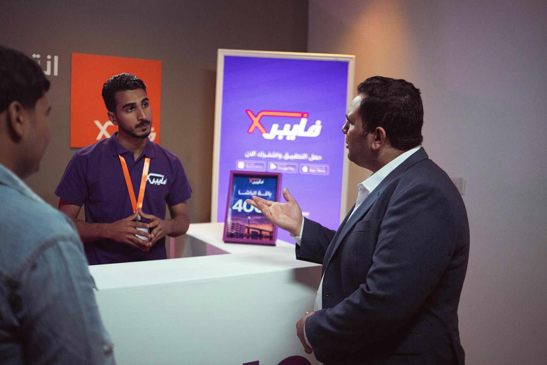 Two people discussing a product catalog at a trade show booth