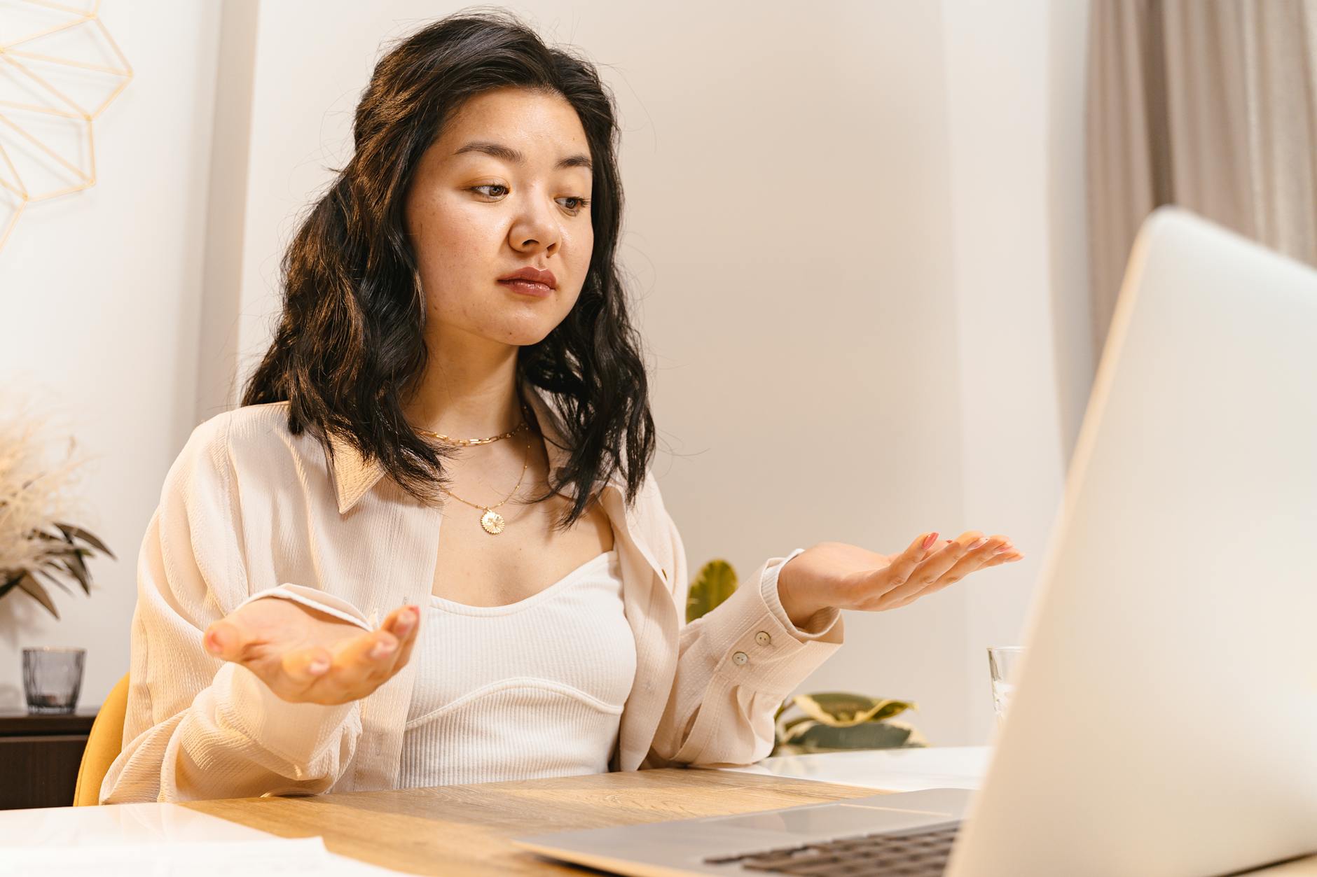 A Korean export manager reviewing LinkedIn analytics on a laptop, looking puzzled at high engagement numbers but an empty inquiry inbox