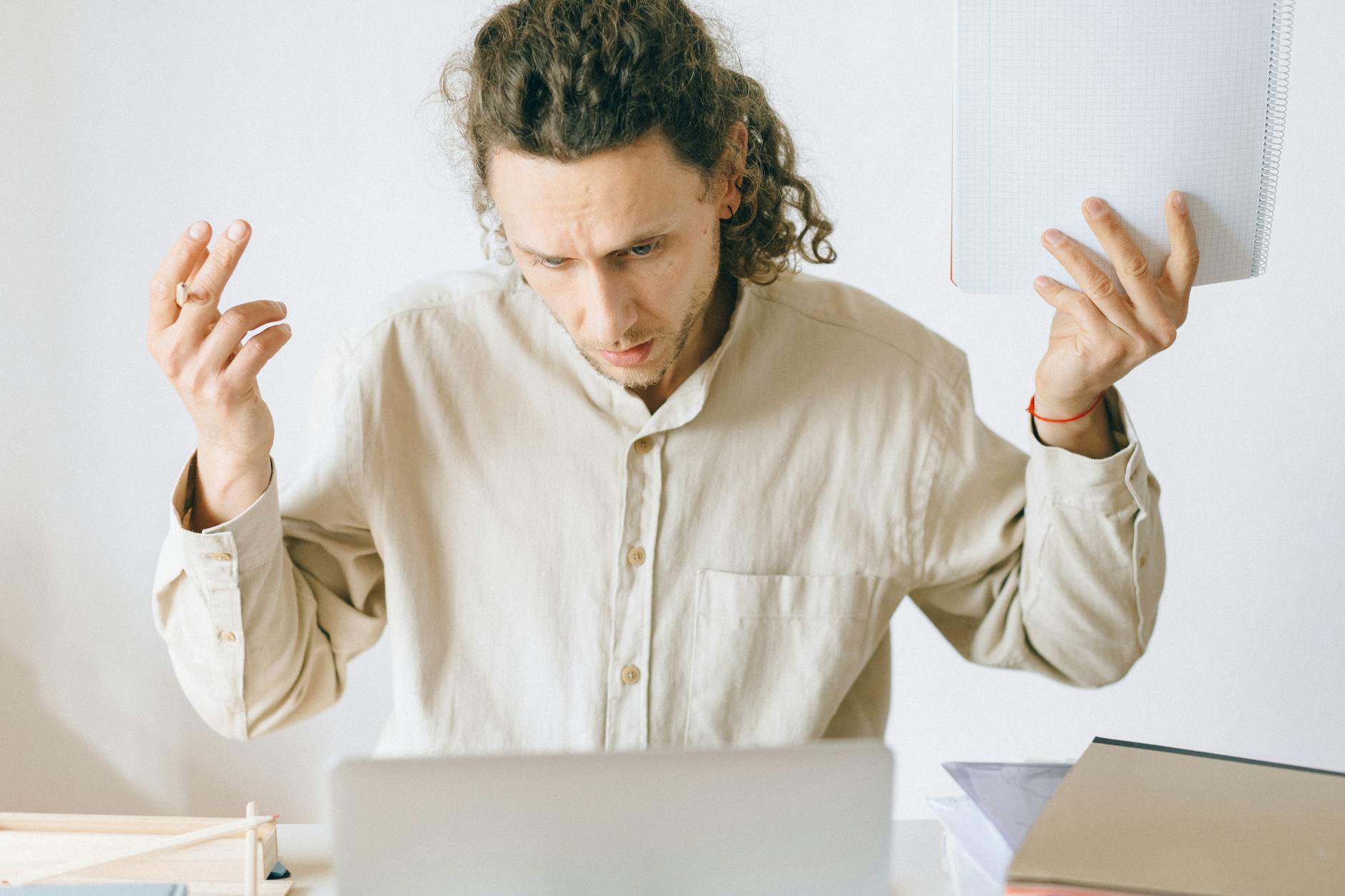A Korean export manager staring at a laptop screen showing unanswered emails, natural office lighting, calm and slightly frustrated expression