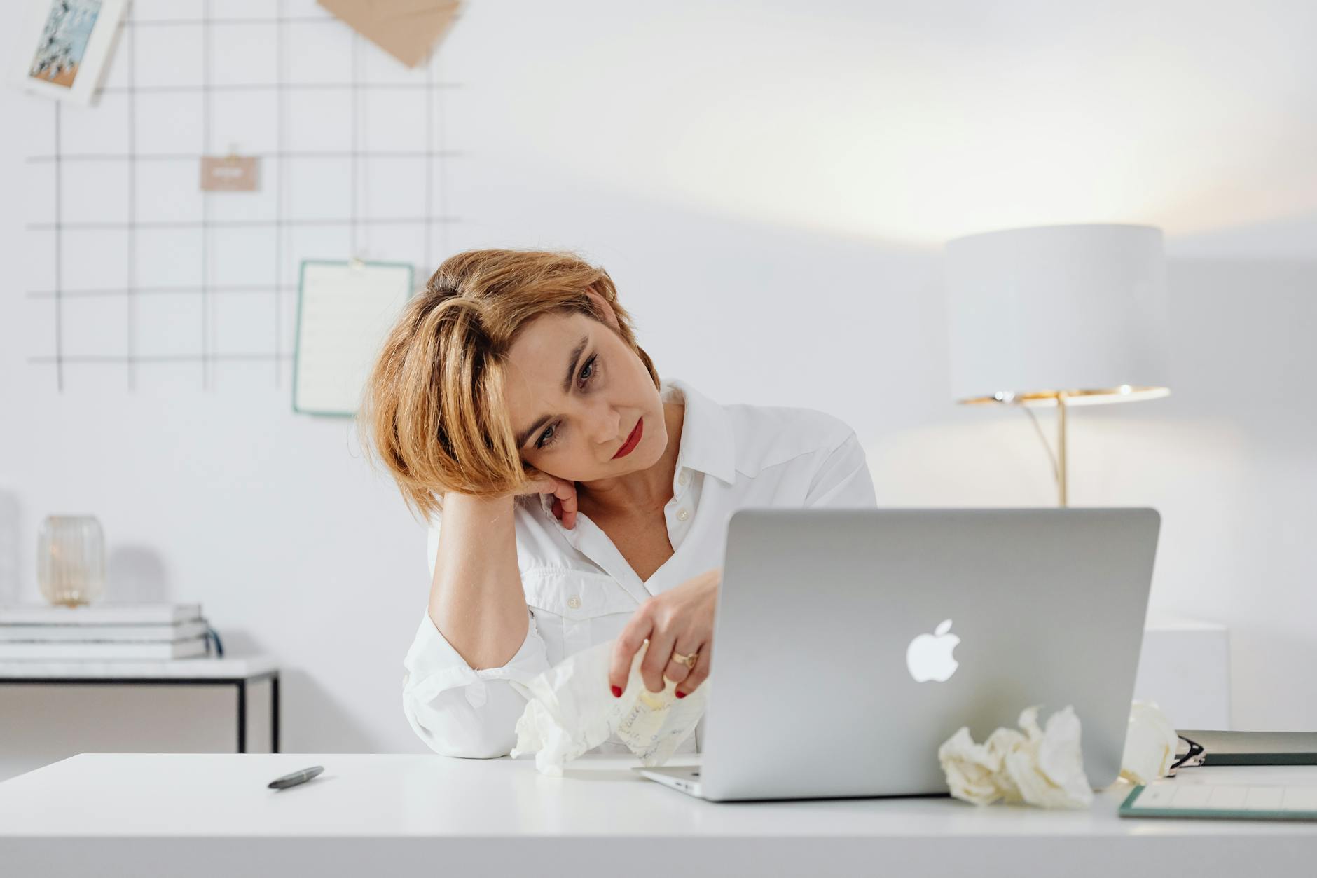 A foreign buyer sitting at an office desk, expressionlessly closing an email on a laptop