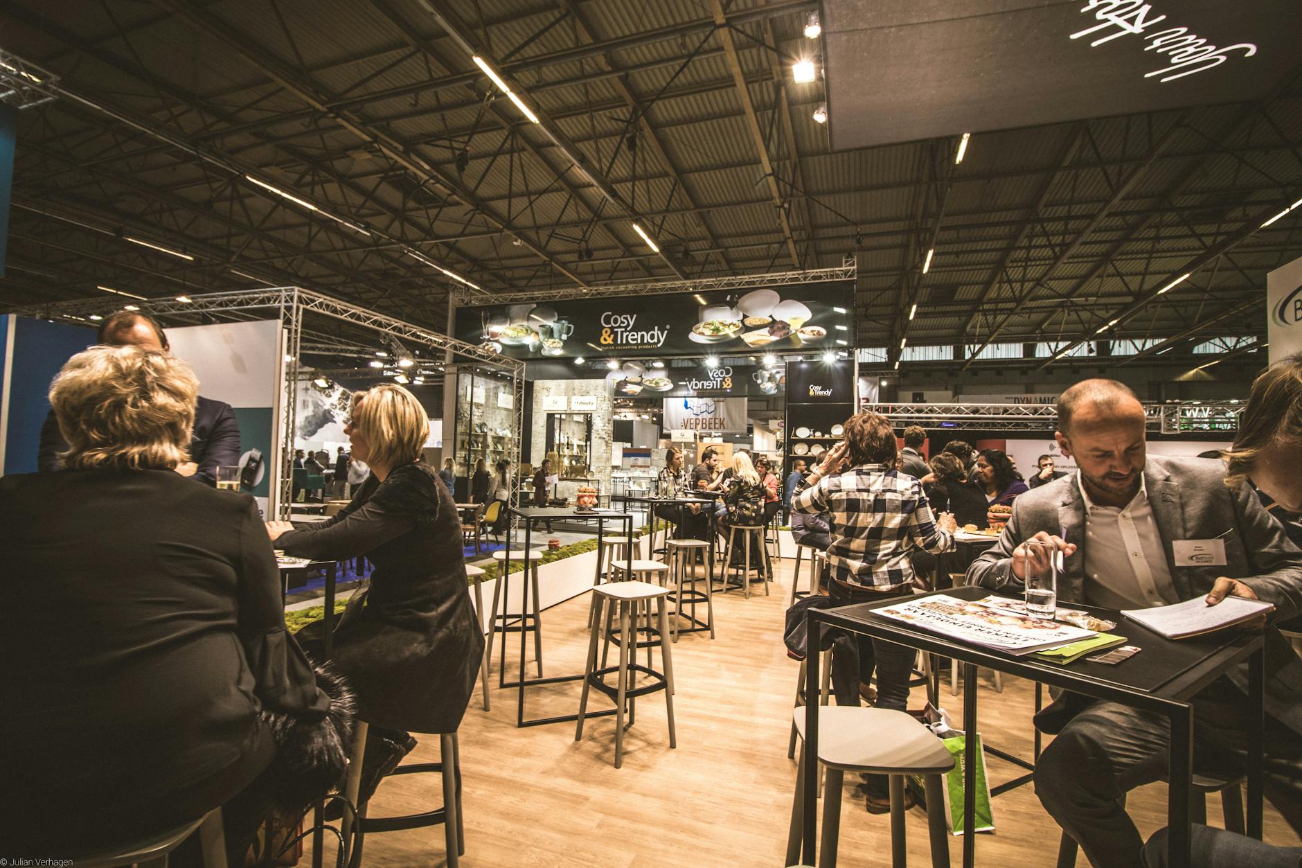 An export sales professional exchanging notes and talking with a foreign buyer at a trade show booth