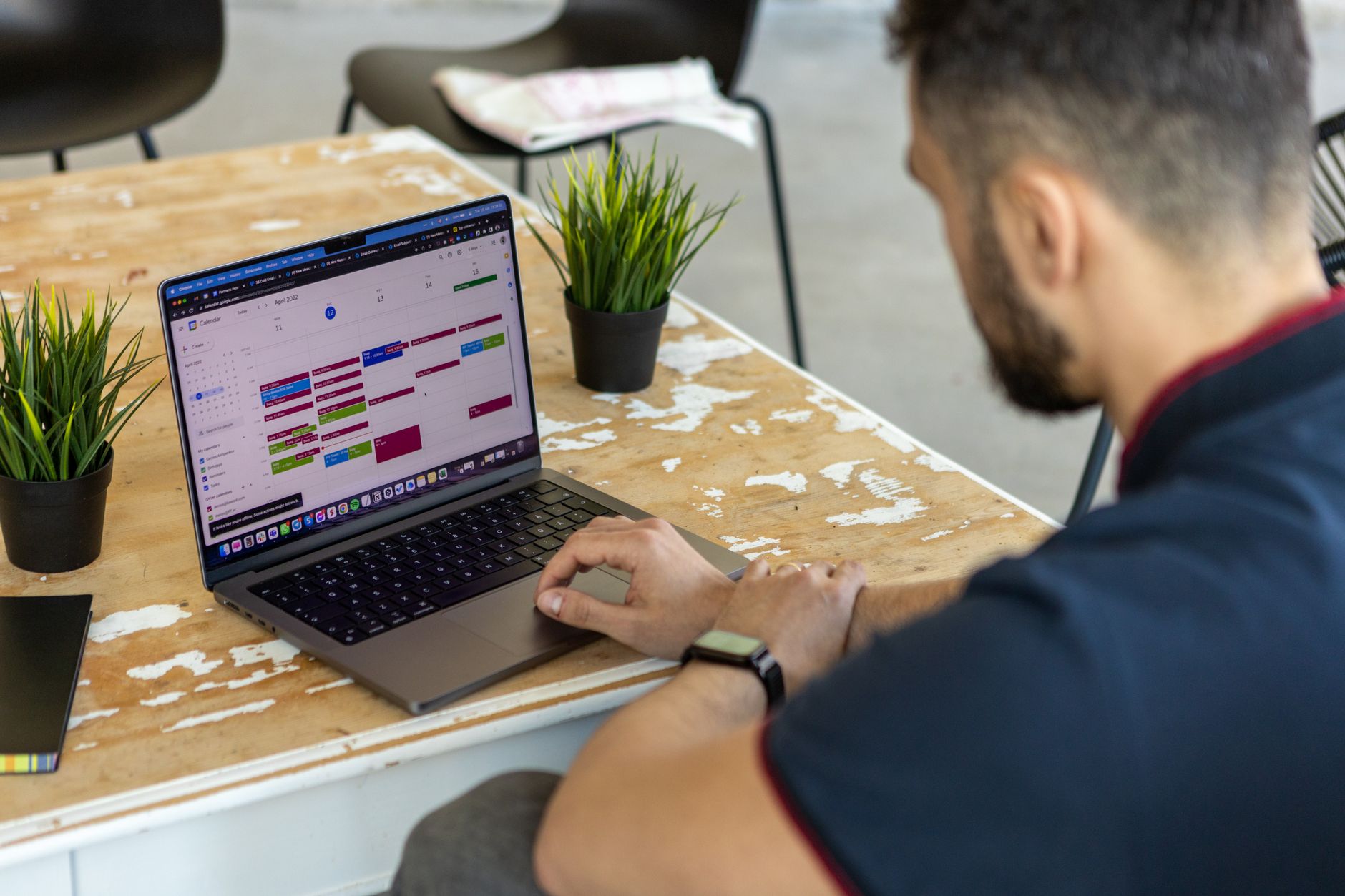 Seorang profesional menatap aplikasi kalender di smartphone sambil berpikir