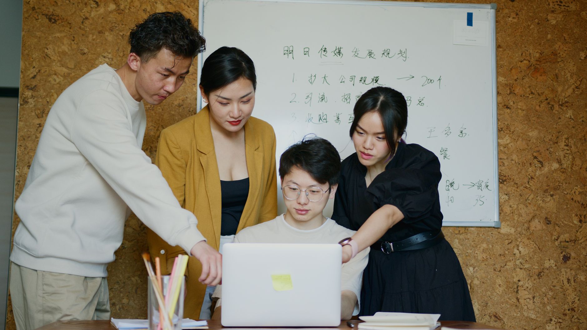 오픈 오피스에서 혼자 빠르게 타이핑하는 개발자 뒤로, 다른 팀원들이 화이트보드 앞에 모여 복잡한 다이어그램을 보며 논의하는 장면