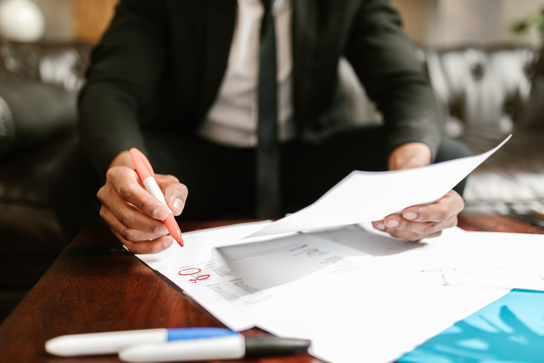 A financial analyst examining a printed S-1 document on a desk with highlighted sections, coffee cup beside it