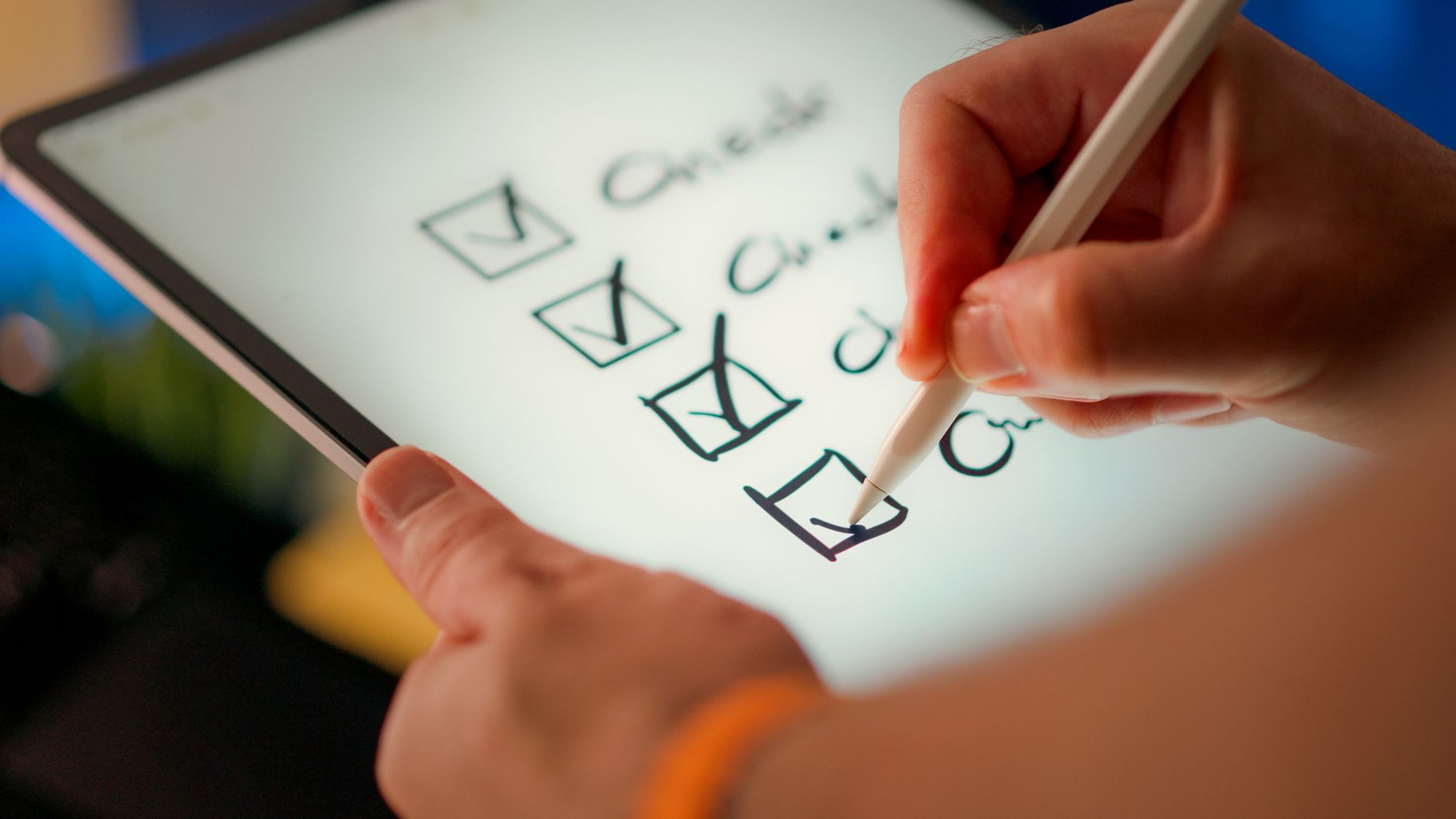 Multiple vendor logos displayed on a screen as a person evaluates and compares them with a checklist on paper