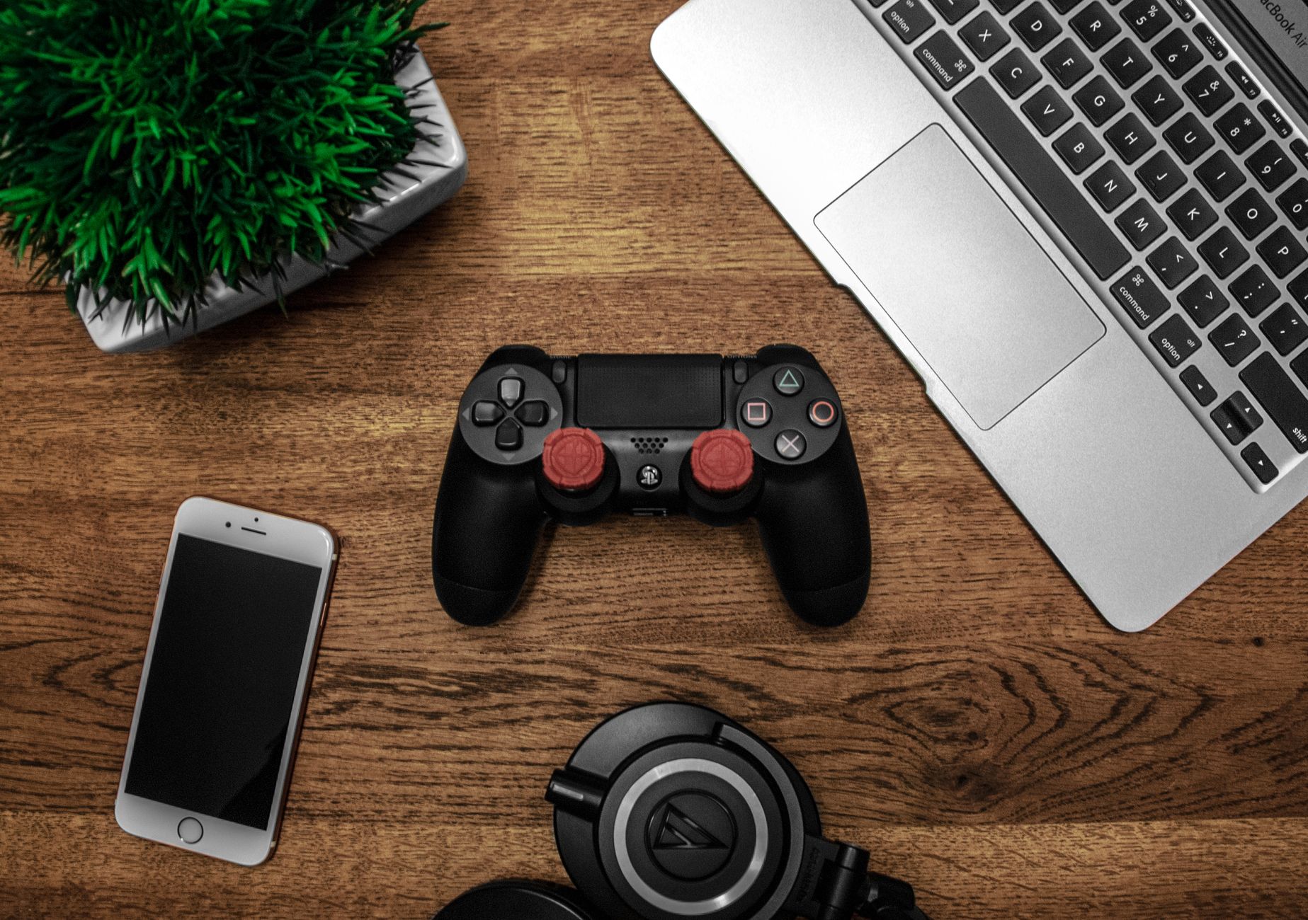 A warm, softly lit office desk with a classic red gaming controller resting next to a neatly organized financial report showing upward trends.