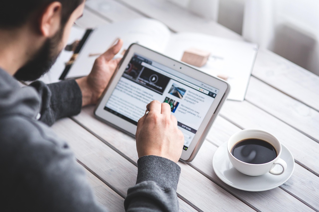 A small export company marketer reviewing a content calendar on a tablet, with LinkedIn, email, and a blog dashboard open in different tabs